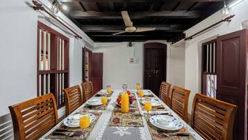 Comedor con una mesa larga dispuesta para seis personas, rodeada de sillas de madera.