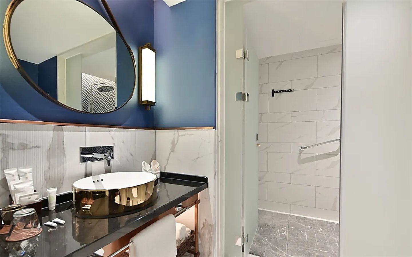 Un baño moderno con un lavabo redondo, un espejo grande y una zona de ducha.