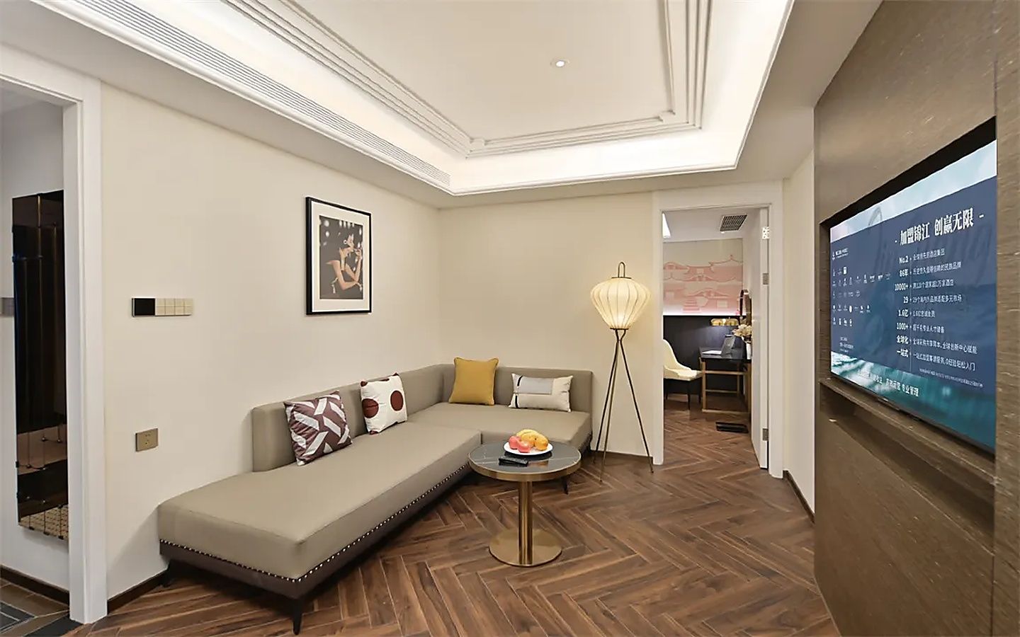 Ein modernes Wohnzimmer mit einer Couch, einem kleinen runden Tisch mit Früchten, einer Stehlampe und einem Fernseher, der Text anzeigt.