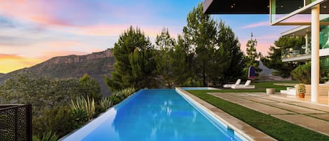 A modern pool with a clear view of mountains in the background.