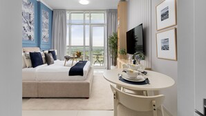 A modern hotel room with a large bed, a dining area, and a TV. - Elegant Studio Retreat in Damac Hills (Dubai)