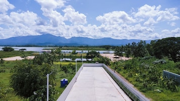 Un sendero de concreto que conduce a un edificio con vistas a montañas y un lago.