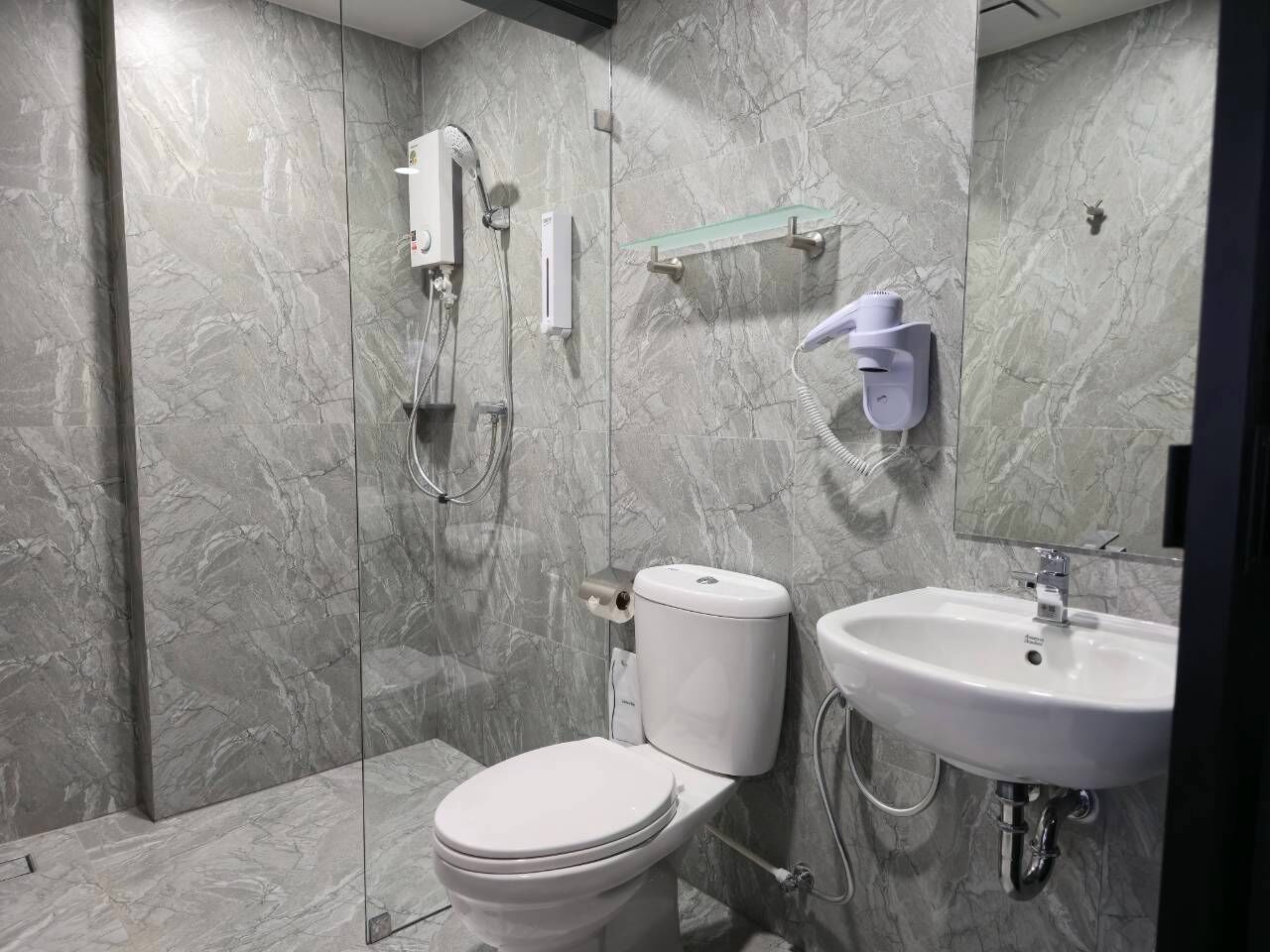 Standaard tweepersoonskamer | Badkamer | Een douche, een haardroger, handdoeken, zeep