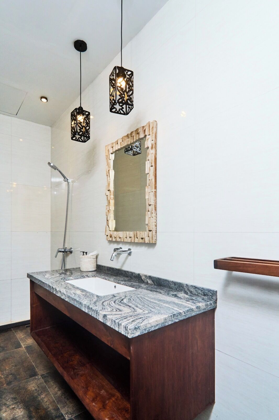 A modern bathroom with a marble sink, wooden vanity, and a unique mirror frame.
