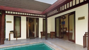 A pool area with a clear pool, wooden deck, and a room labeled 'MAWAR'.