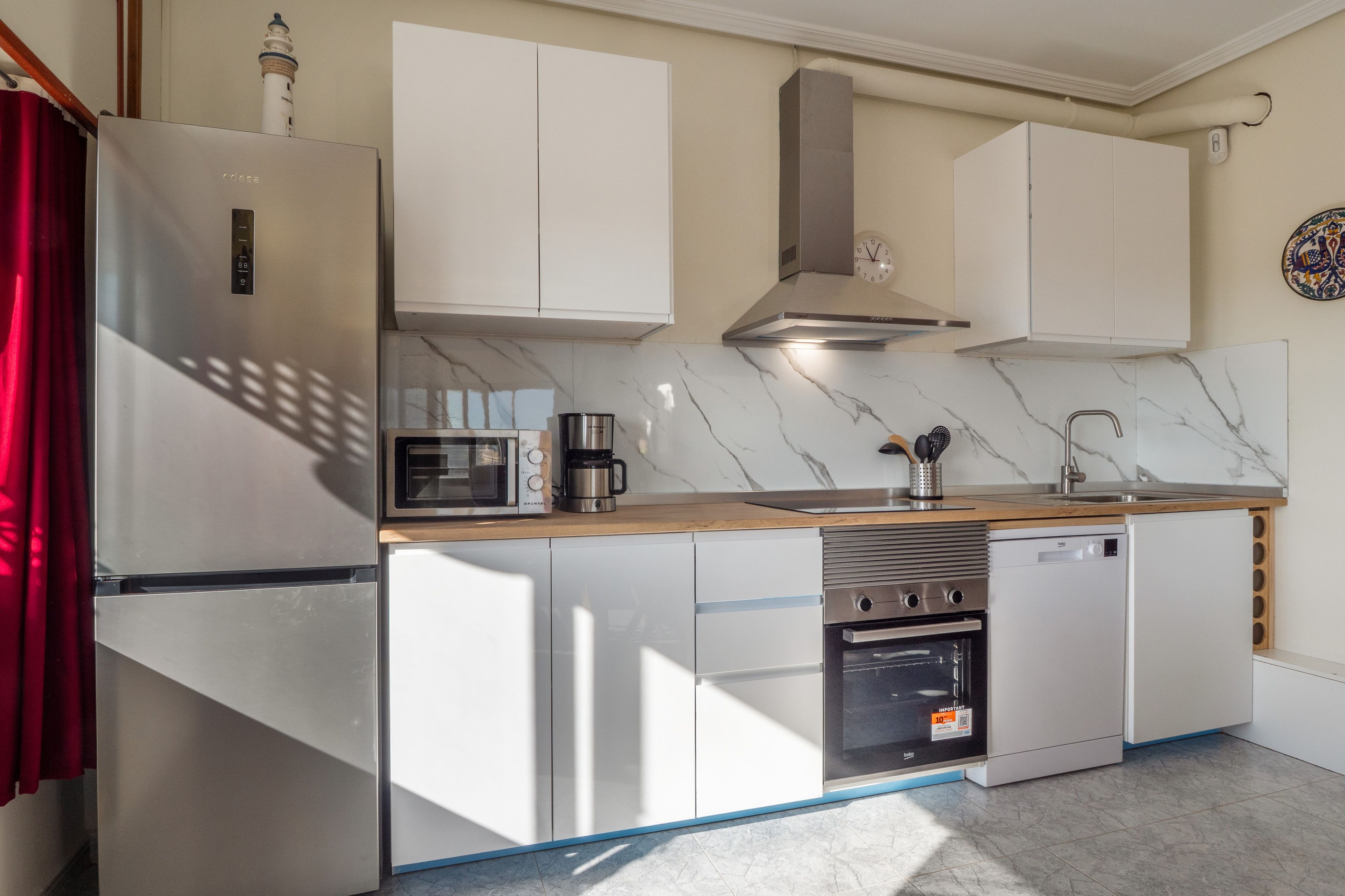 A modern kitchen with a built-in oven, microwave, and stainless steel appliances.