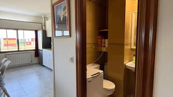 Un baño con inodoro, lavamanos y ducha.