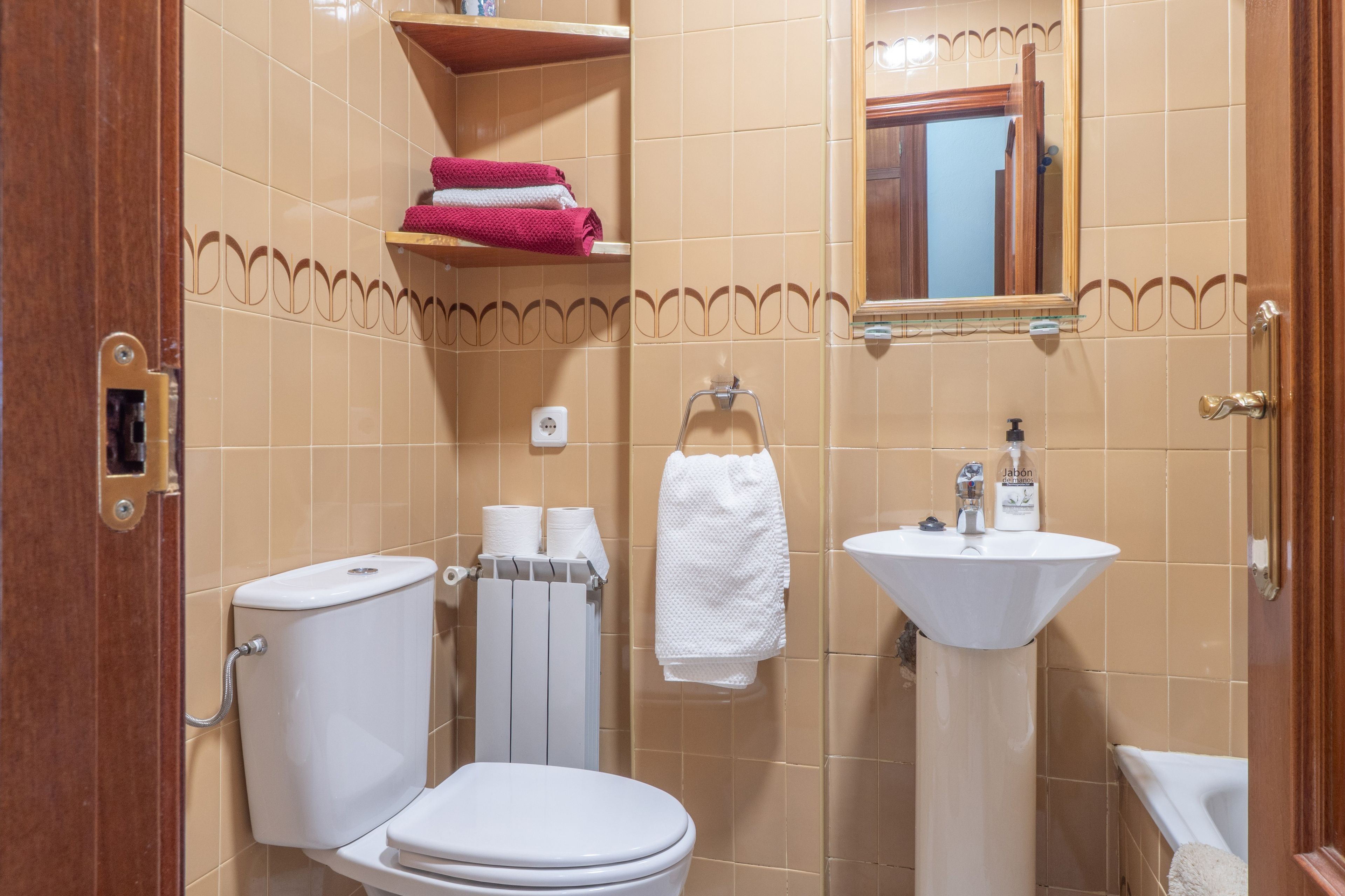 Une salle de bain équipée de toilettes, d’un lavabo et d’un porte-serviettes.