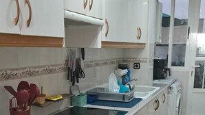 A kitchen with white cabinets, a black countertop, and a built-in oven. - Your home in Altea! 200 m from the beach / bright / 2 bedrooms / fully equipped / beautifully decorated. (Altea)