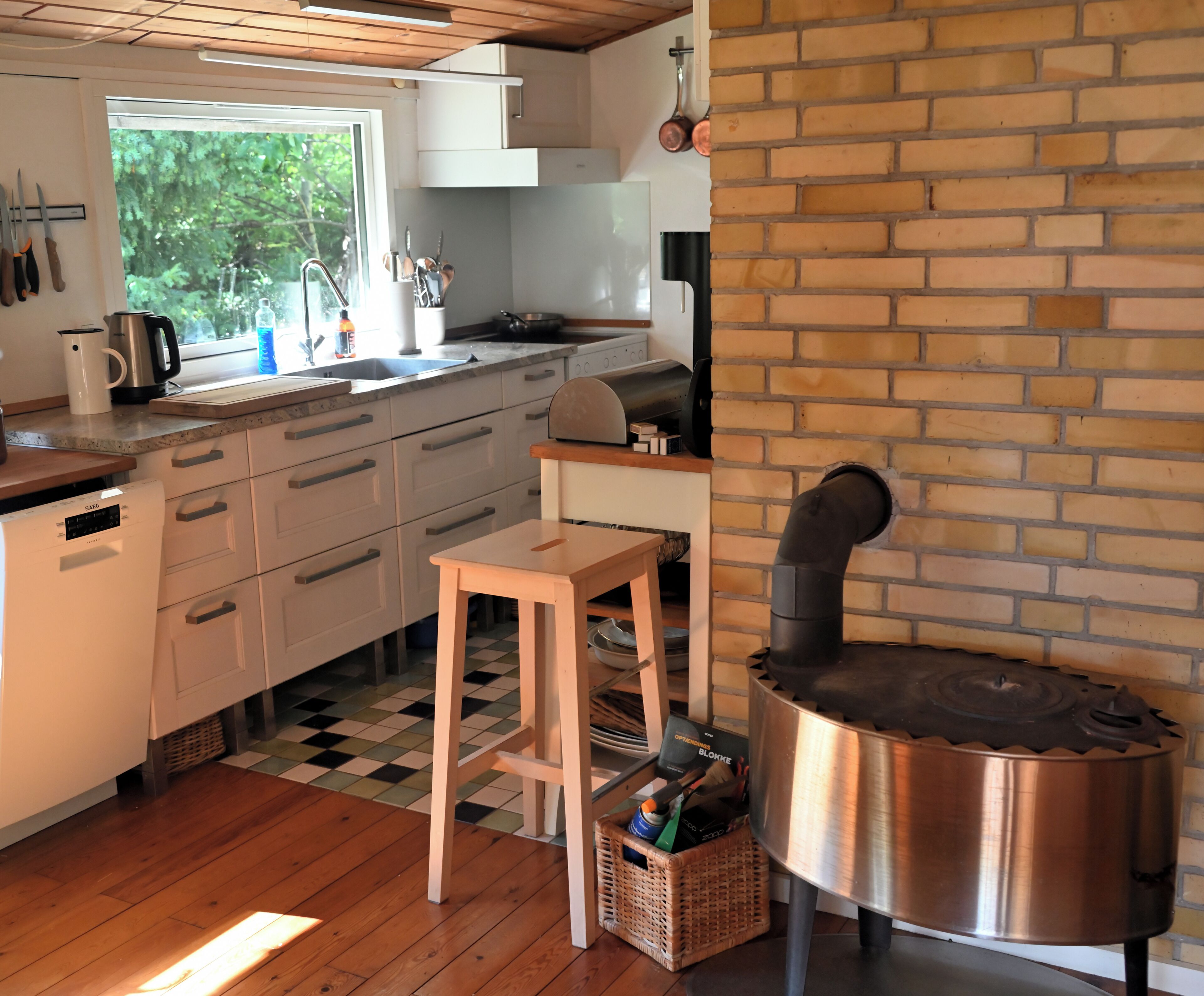 A kitchen with a brick wall, a wooden table, and a stove.