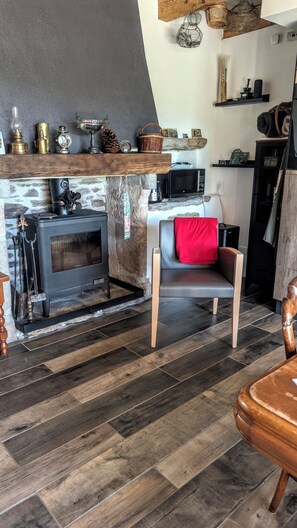A cozy living room with a stone fireplace, a modern sofa, and a wooden coffee table.