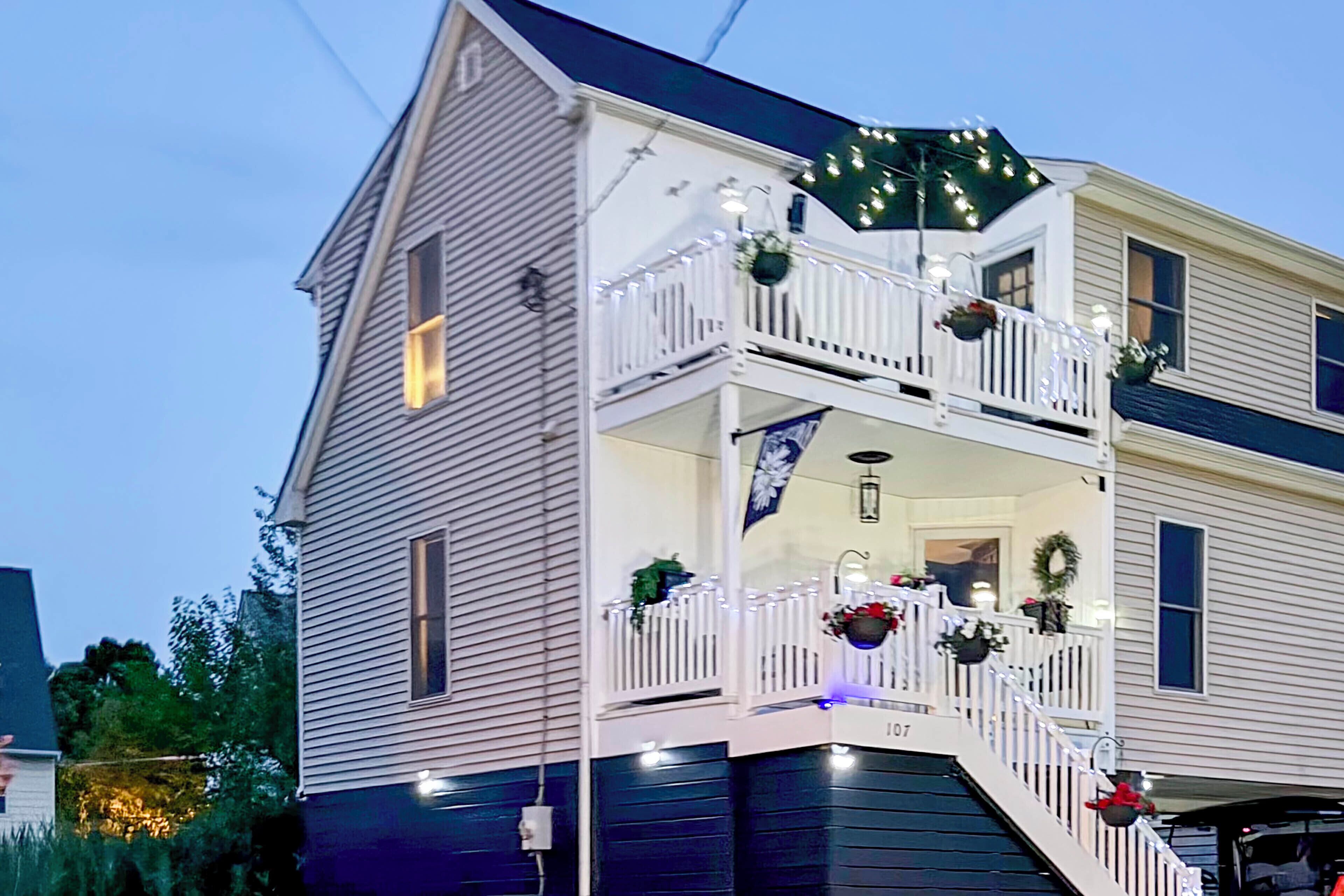 Una casa de dos pisos con un balcón, decorada con luces y guirnaldas.