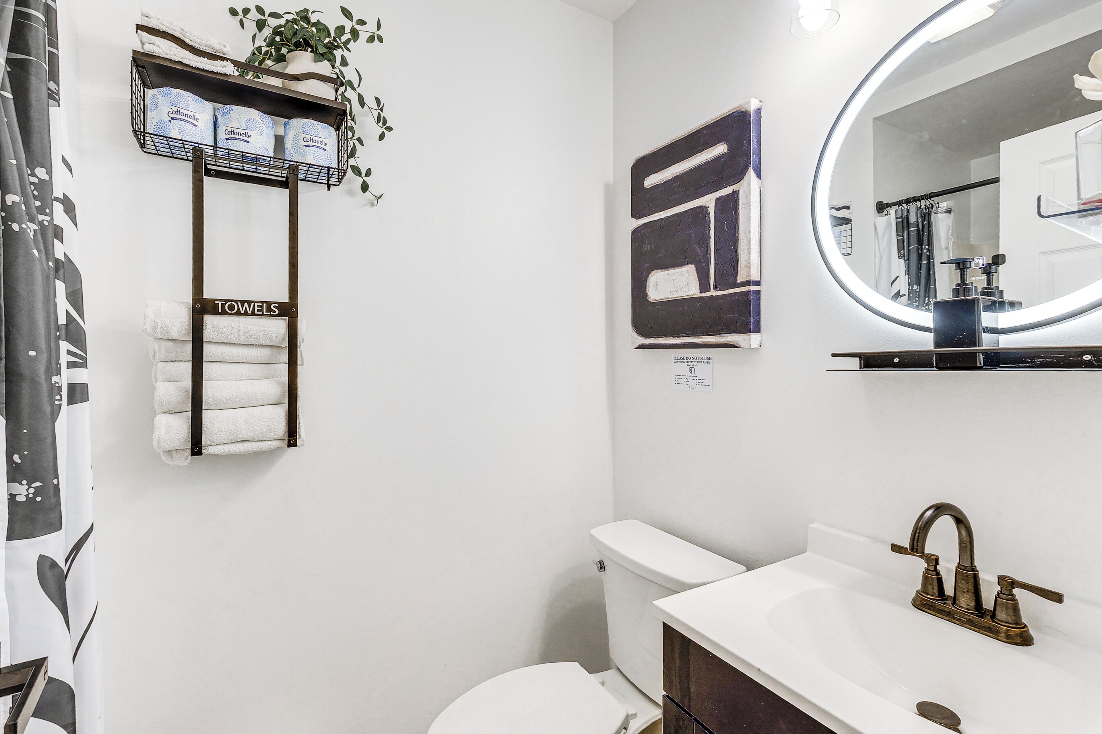 Een badkamer met toilet, wastafel en handdoekhouder.