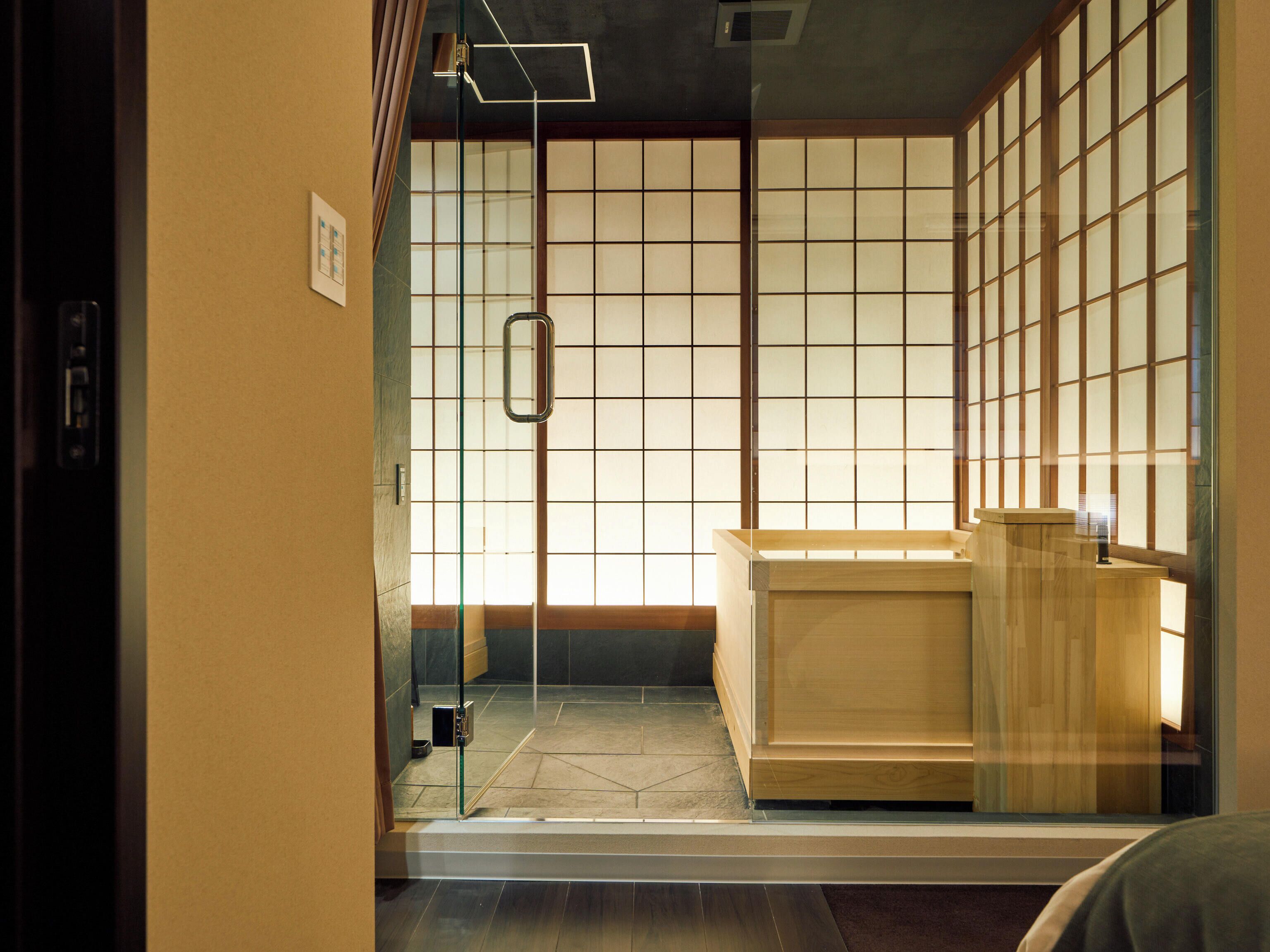Um quarto em estilo japonês tradicional, com portas de correr, uma mesa de recepção e soalho em azulejo.