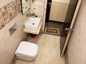 Een kleine badkamer met toilet, wastafel en douche.