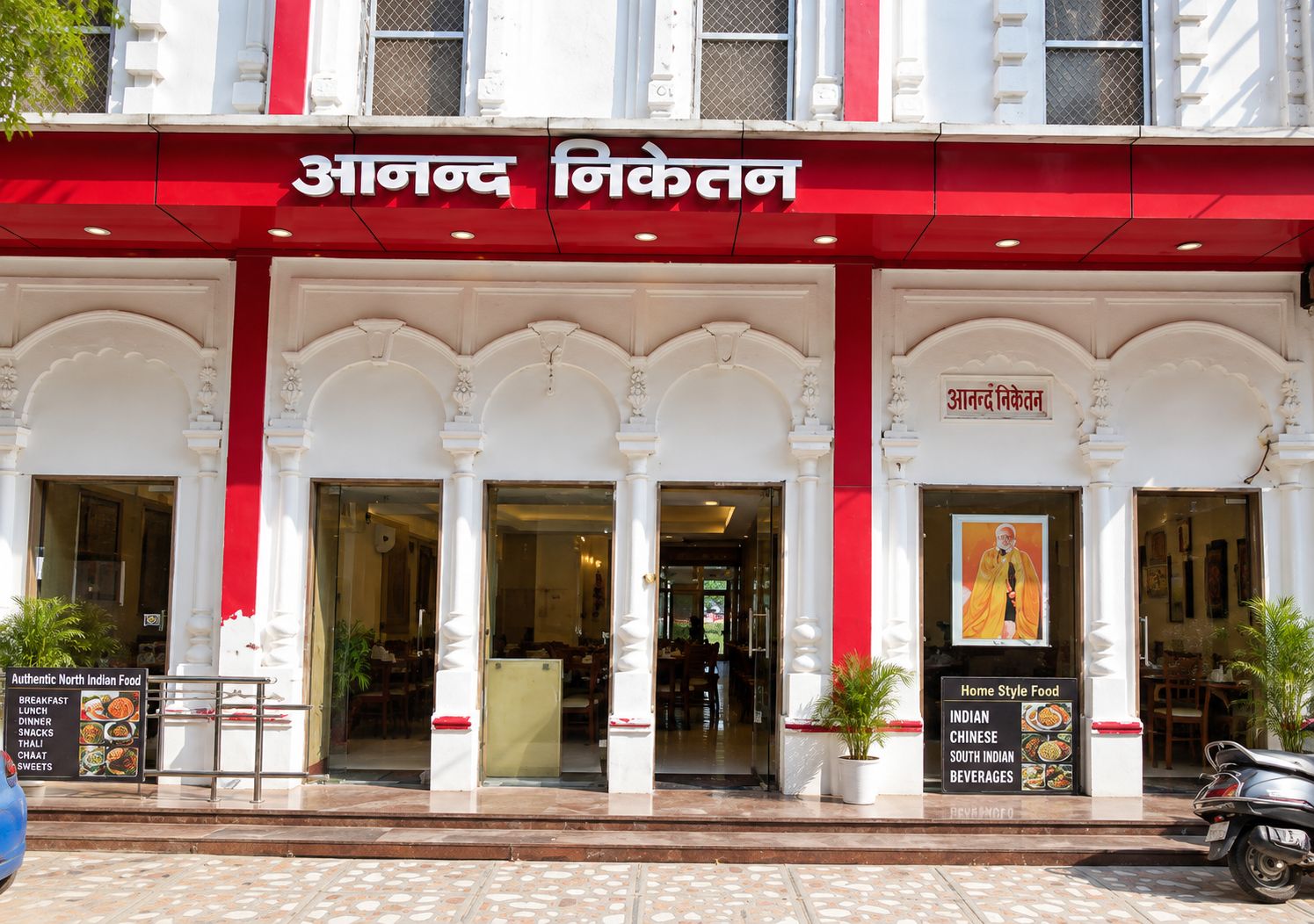 A restaurant with a red awning and white columns, featuring signs for North Indian and Home Style food.