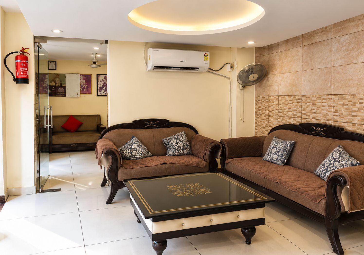 A living room with two sofas, a coffee table, and a wall-mounted air conditioner.