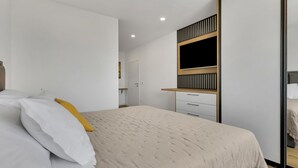 A modern bedroom with a bed, a wardrobe, and a television. - Villa Baculla by Villas Guide (Makarska)