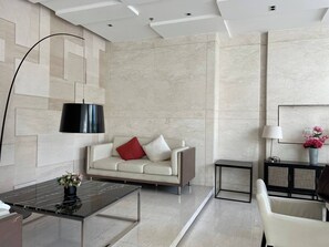 A modern living room with a sofa, coffee table, and a lamp.