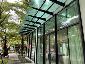 A modern building with large glass windows and a metal framework structure. - Accommodations room with balcony view Sukhumvit77 (Khet Suan Luang)