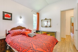 Een slaapkamer met een bed, een dressoir en een spiegel.