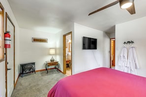 Ein Schlafzimmer mit einem Bett, einem Feuerlöscher, einem Fernseher und einem Kleiderhaken.