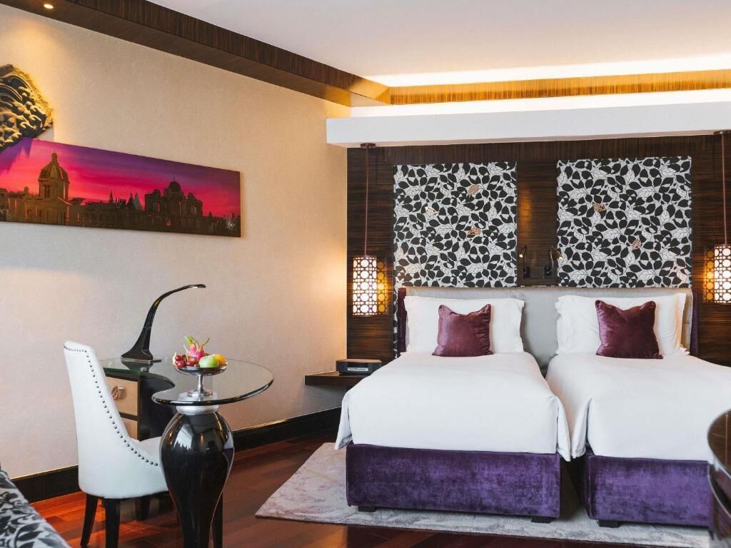 Une chambre d’hôtel avec deux lits, une table à manger et une chaise.