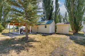 A small, single-story building with a covered patio area and a garage. - Bear Lake Cabin w/ Spacious Yard + Patio! (Saint Charles)