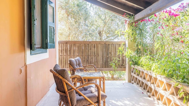 A covered patio with wicker furniture and a wooden fence. - Zanteva-Psophis cottage (Zakynthos)