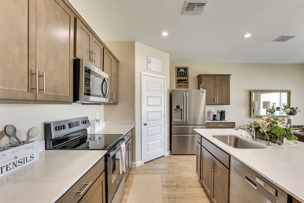 A modern kitchen with stainless steel appliances, wooden cabinets, and a clean, organized layout.