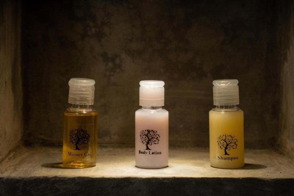Tres botellas de productos de higiene personal sobre una repisa.