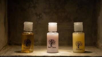 Tres botellas de productos de higiene personal sobre una repisa.