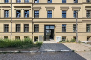 En bygning med flere etager, en symmetrisk facade, store vinduer og en central indgang.