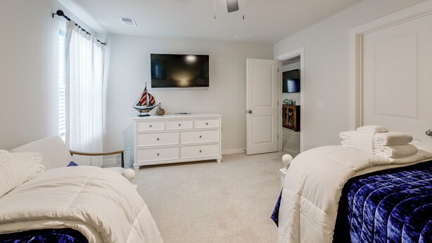 A bedroom with two beds, a ceiling fan, a TV, and a dresser. - May River Fun! Home 9 Mi to Hilton Head Island (Bluffton)