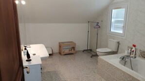 A bathroom with a toilet, sink, and shower area.