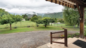 A covered outdoor area with a gravel path leading to a wooden deck.