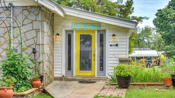 Un bâtiment avec une porte jaune et une enseigne sur laquelle on peut lire « EST ».