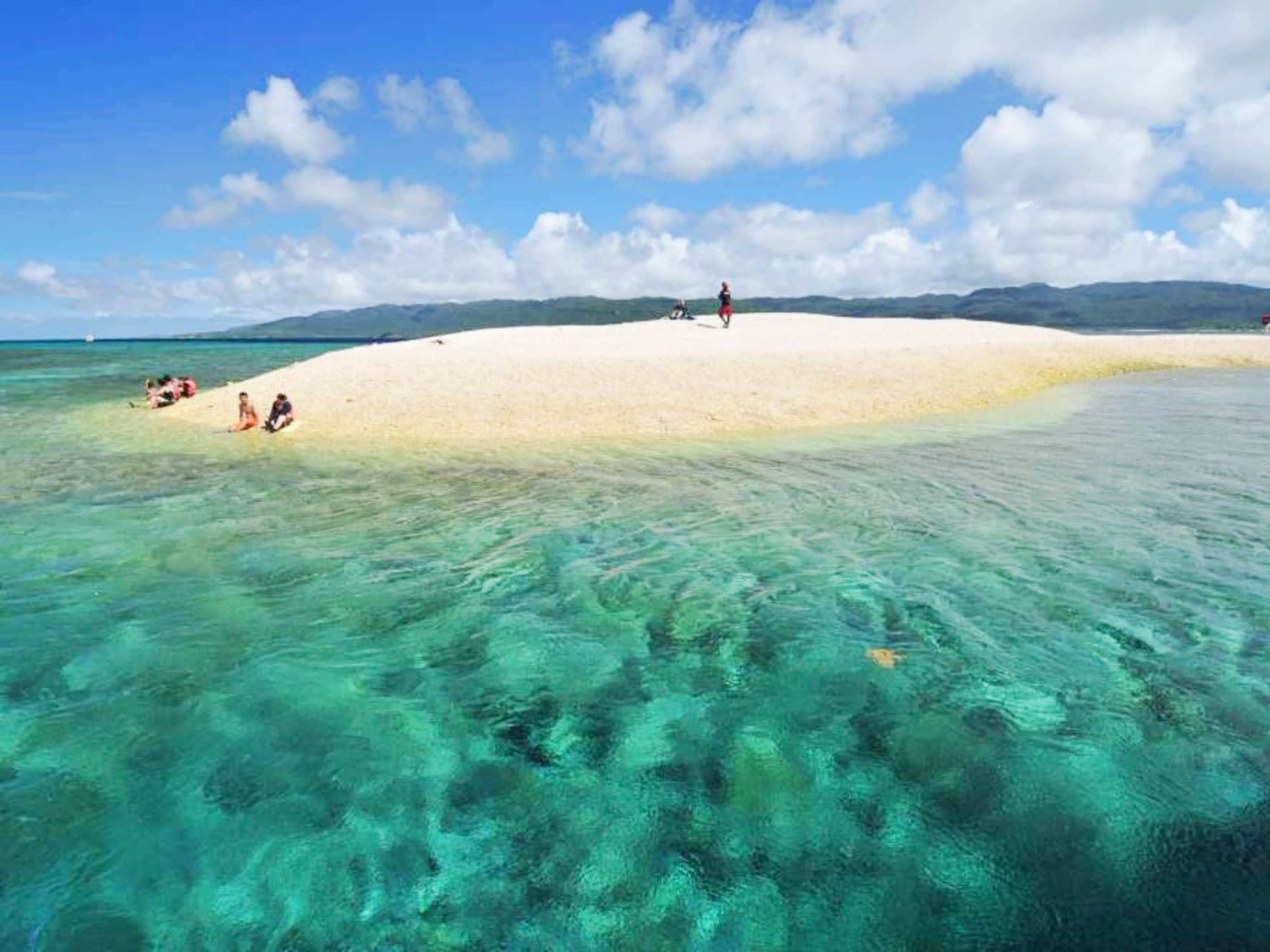 Uma praia com águas turquesa cristalinas e uma faixa de areia.