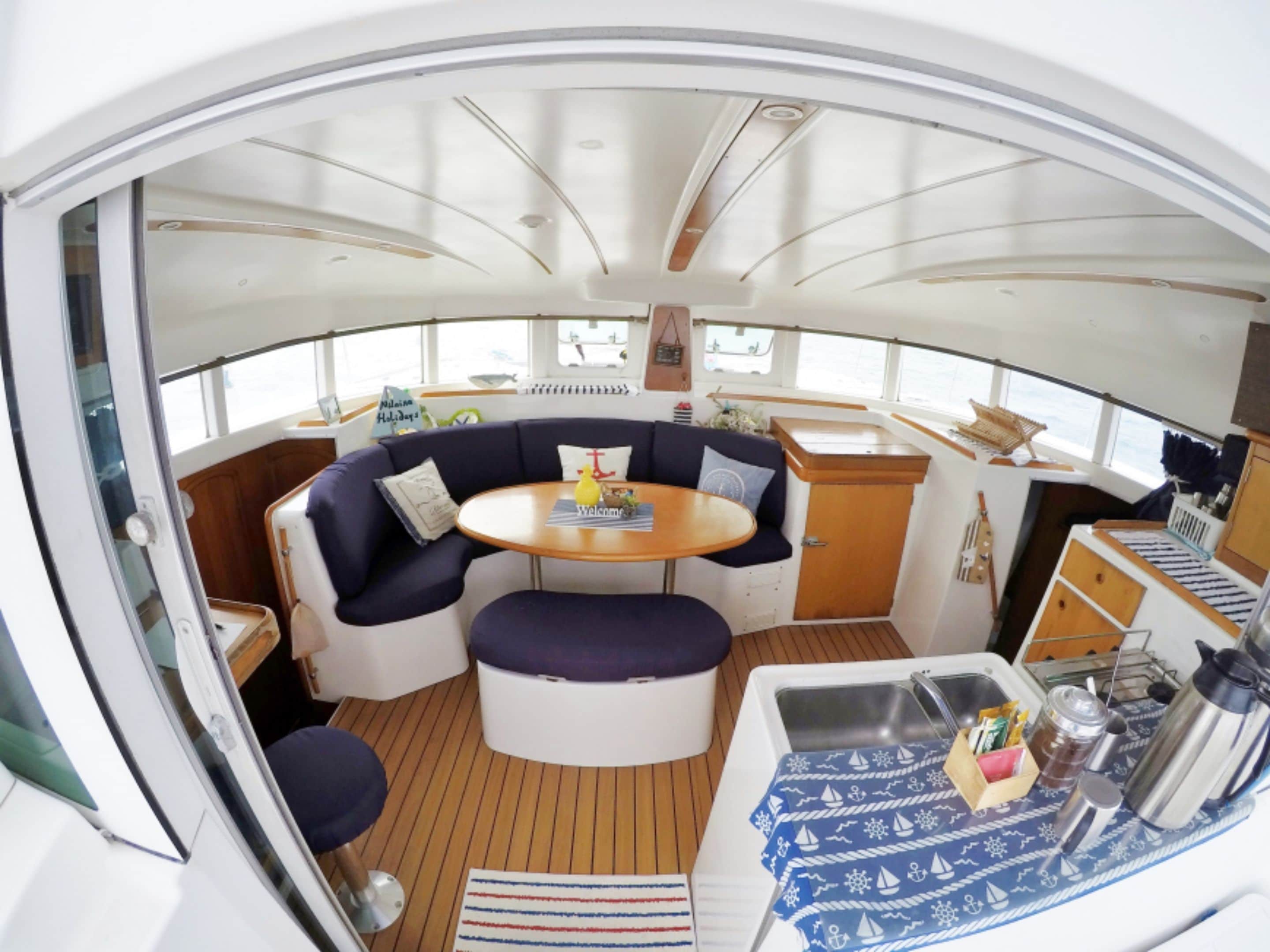 Un intérieur chaleureux avec une table ronde, des sièges confortables, un petit coin cuisine et une fenêtre donnant sur l’extérieur.