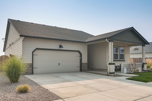 A single-story house with a garage, a covered porch, and a small front yard with landscaping.