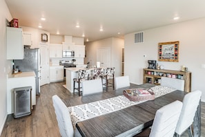 A modern kitchen with white cabinets, a stainless steel refrigerator, and a microwave.
