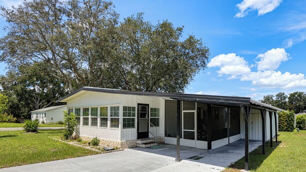 A single-story house with a covered porch, a front door, and a small front yard.