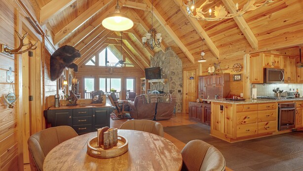 A spacious wooden interior with a dining area, kitchen, and living space. - Mountain Top Lodge with Amazing Vista (Jasper)