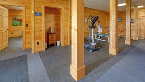 A gym with wooden walls, exercise equipment, and a sign indicating it's part of Edisto Beach. - Mountain Top Lodge with Amazing Vista (Jasper)