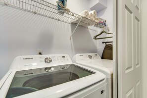 A laundry area with a Samsung front-loading washer and dryer, a drying rack, and a towel rack. - 4 Mi to Six Flags! Group Retreat in Mableton (Mableton)
