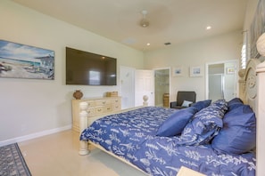 Ein Schlafzimmer mit Bett, Kommode, Fernseher und Bildern an der Wand.