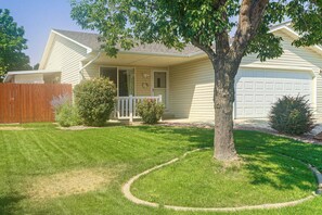 A residential house with a front porch, a garage, and a well-maintained lawn. - Grand Junction Home w/ Patio: Shop, Dine & Hike! (Grand Junction)