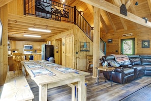Ein großzügiges Holzhaus-Interieur mit Essbereich, Küche und einer Ledersitzgruppe.