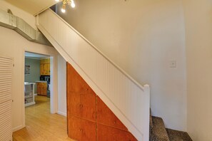 A staircase with a wooden handrail and a white wall.