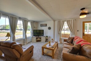 Een woonkamer met een televisie, bank en salontafel.